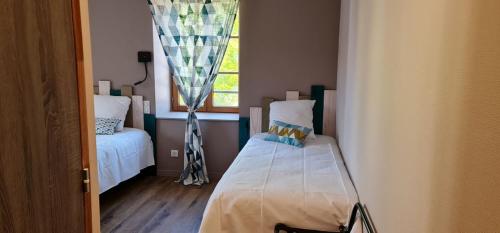 a small room with a bed and a window at L'auberge De La Source in La Valla