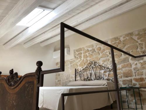een slaapkamer met een bed en een stenen muur bij Chicchi Di Melograno in Modica