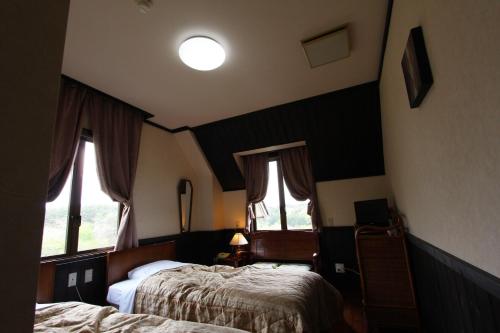 a hotel room with two beds and two windows at Matsushima Petit Hotel Bistro Abalon in Matsushima