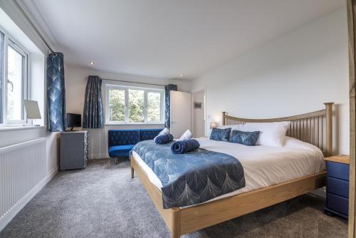 a bedroom with a large bed and a blue chair at Martello View - 3 Bedroom Holiday Home - Llanreath in Pembroke Dock