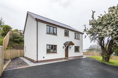 a white house with a driveway at Martello View - 3 Bedroom Holiday Home - Llanreath in Pembroke Dock