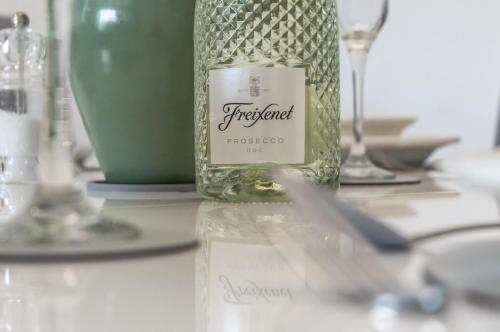 a bottle of wine sitting on a table at Martello View - 3 Bedroom Holiday Home - Llanreath in Pembroke Dock