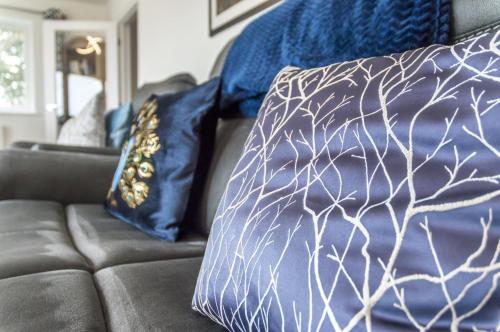 a couch with two blue and white pillows on it at Martello View - 3 Bedroom Holiday Home - Llanreath in Pembroke Dock