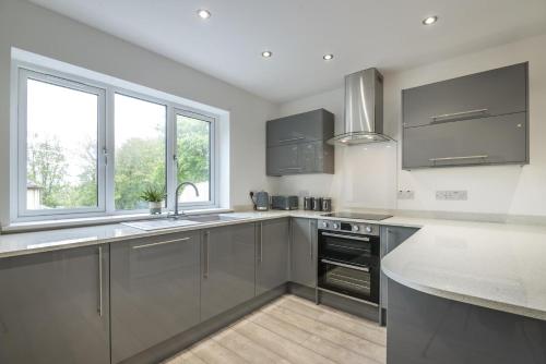 a kitchen with stainless steel appliances and windows at Martello View - 3 Bedroom Holiday Home - Llanreath in Pembroke Dock