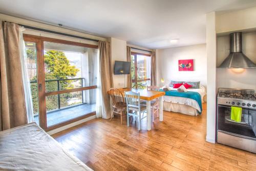 1 dormitorio con 1 cama y 1 mesa con comedor en Dte Mafalda en el centro de San Carlos de Bariloche.