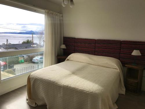 a bedroom with a bed and a large window at Araucaria in San Carlos de Bariloche