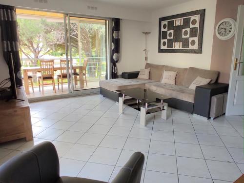 un salon avec un canapé et une table dans l'établissement résidence avec piscine, à Fréjus