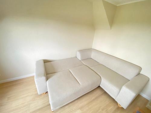 a white couch in a corner of a room at Strandliebe Markgrafenheide in Rostock