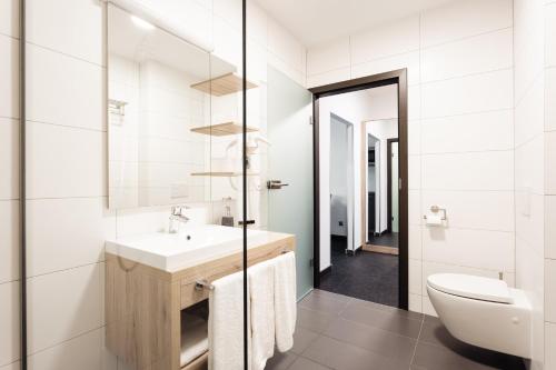 a bathroom with a sink and a toilet at Hotel Smart Liv'in in Böheimkirchen