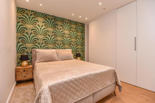 een slaapkamer met een bed en een groene en witte muur bij GoKlaipeda in Klaipėda