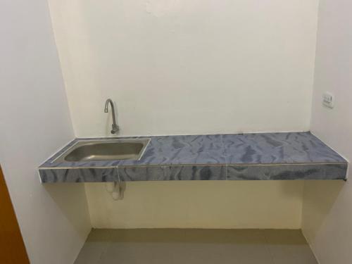 a kitchen counter with a sink in a room at La Riesa Dorm in Tarlac