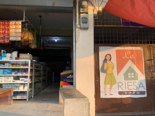 een winkel met een bord op de deur van een winkel bij La Riesa Dorm in Tarlac