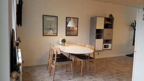 Løkken centrum ferielejlighed-apartment 4F في لوكين: غرفة طعام مع طاولة بيضاء وكراسي