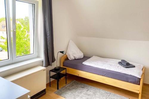a small bedroom with a bed and a window at Worker Apartments Bernsdorf-Wiednitz in Bernsdorf