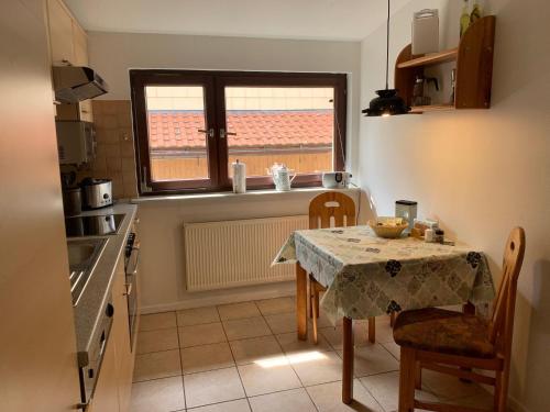 a small kitchen with a table and a window at Ferienwohnung Parkblick in Dransfeld