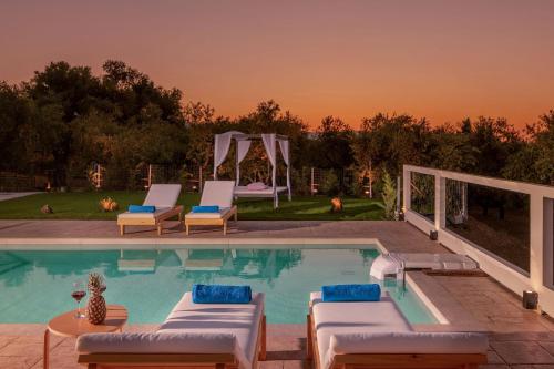 a swimming pool with lounge chairs and a table at Farao Villa in Kypseli