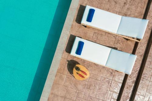 una vista aérea de una piscina con 2 sillas y un plátano en Farao Villa en Kypseli
