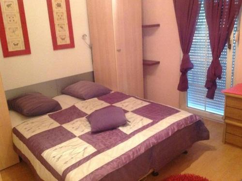Un dormitorio con una cama con almohadas moradas. en Apartment in Vrsi with Balcony, Air conditioning, Wi-Fi (4824-2), en Vrsi