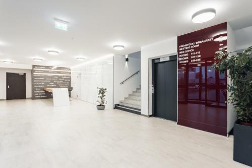 an office lobby with a door and potted plants at Hotel Smart Liv'in in Böheimkirchen