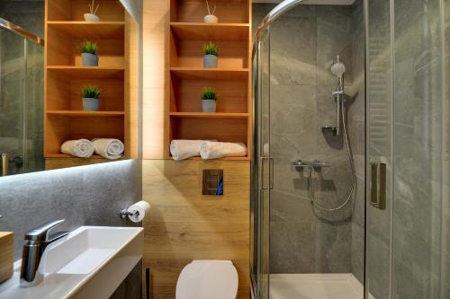 y baño con ducha, aseo y lavamanos. en Apartament Nad Łomnicą Centrum en Karpacz