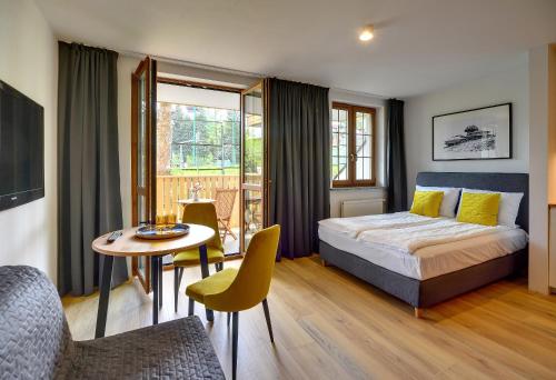 a bedroom with a bed and a table and chairs at Apartament Nad Łomnicą Centrum in Karpacz