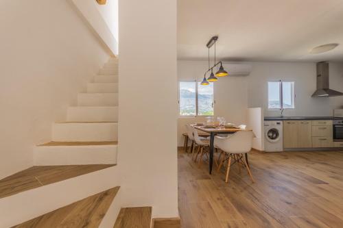 uma cozinha e sala de jantar com escadas e uma mesa e cadeiras em Wonderful Views Terrace 3BR Cottage - BBQ - AC em Altea