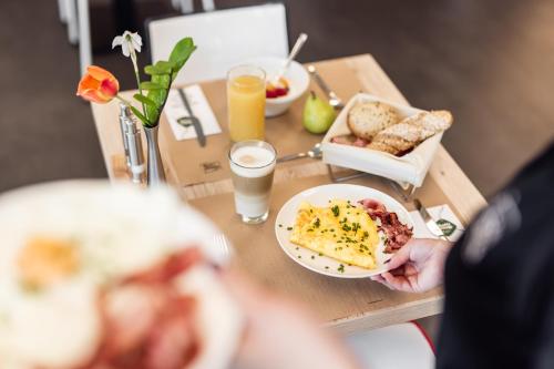 a table with a plate of breakfast food and drinks at Hotel Smart Liv'in in Böheimkirchen