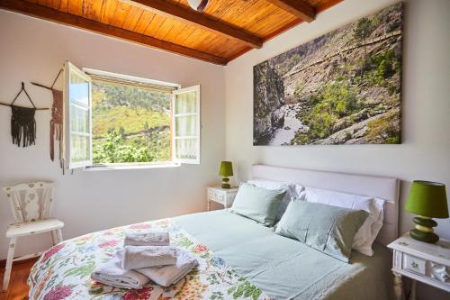 een slaapkamer met een bed en een raam bij Cottage da Paradinha: Passadiços do Paiva - Arouca in Paradinha