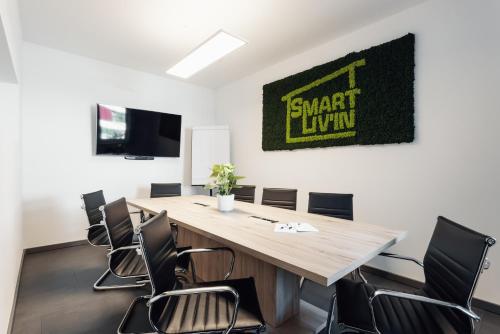 a conference room with a large wooden table and chairs at Hotel Smart Liv'in in Böheimkirchen
