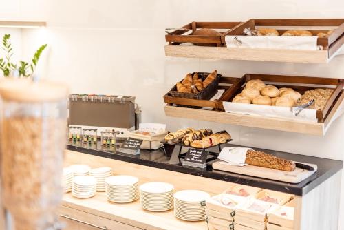 a bakery with bread and pastries on a shelf at Hotel Smart Liv'in in Böheimkirchen