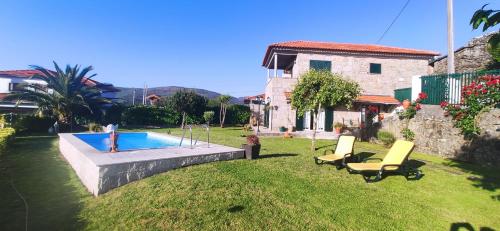 a yard with two chairs and a swimming pool at Casa da Boa Vista em Viadal in Vale de Cambra