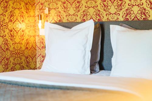 two pillows on a bed in a room at Logement Onze Chambres & Gîtes in Raissac-dʼAude