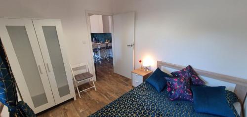 a bedroom with a bed with blue pillows at Kamień Bałtyku Apartament in Debina