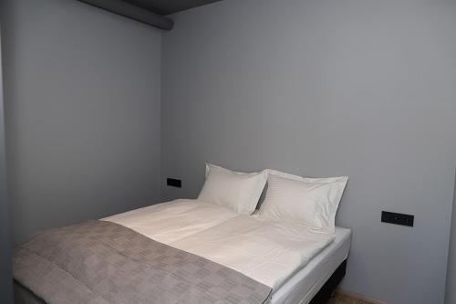 een wit bed met witte kussens in een slaapkamer bij Tryggvabraut 24 One Bedroom Apartment in Akureyri