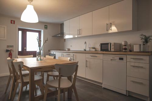 a kitchen and dining room with a wooden table and chairs at Casas Peralta - Marialva in Arouca