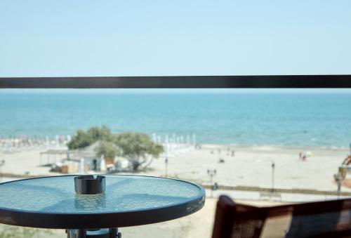 a table with a view of the beach at Hotel Azaleea Mamaia Nord in Mamaia Nord