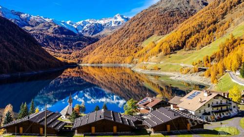 a resort on a lake in the mountains at Dorfblick Appartements & Rooms in Senales