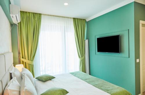 a bedroom with a bed and a window with a television at Hotel Azaleea Mamaia Nord in Mamaia Nord