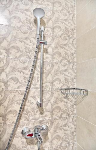 a shower in a bathroom with a wall at Hotel Azaleea Mamaia Nord in Mamaia Nord