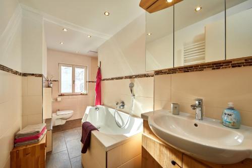 a white bathroom with a sink and a toilet at Apartments Alte Villa in Garmisch-Partenkirchen
