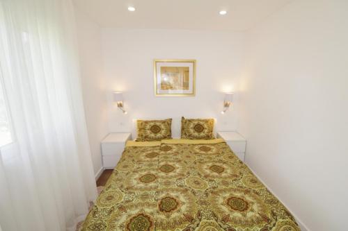 a bedroom with a bed with two pillows at Holiday house PUNTA Umag II in Umag