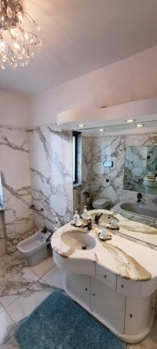 a bathroom with two sinks and a large mirror at La Terrazza Casa Vacanza in Carenno