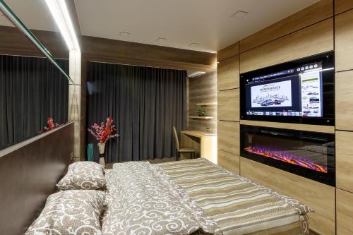 a hotel room with a bed and a flat screen tv at City center. Panoramic windows. Fireplace. in Chişinău