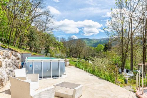 a patio with a pool and chairs and a table at Le Mas de la Coupière in Serres-sur-Arget