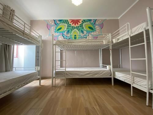 a room with bunk beds with a mural on the wall at Orange Terrace Hostel in Albufeira