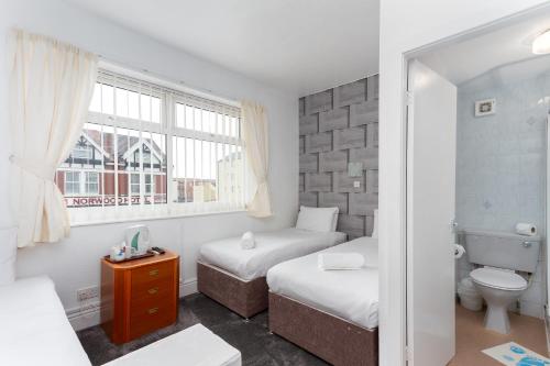 a small room with two beds and a window at The Sandringham Court Hotel & Apartment Welcoming Large and Small Groups for 16 years in Blackpool