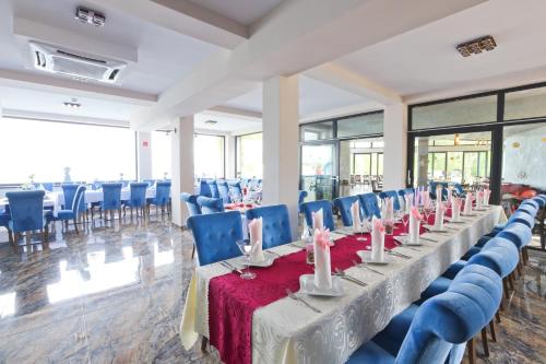 a room with a long table and blue chairs at Hotel Prístav in Trstená