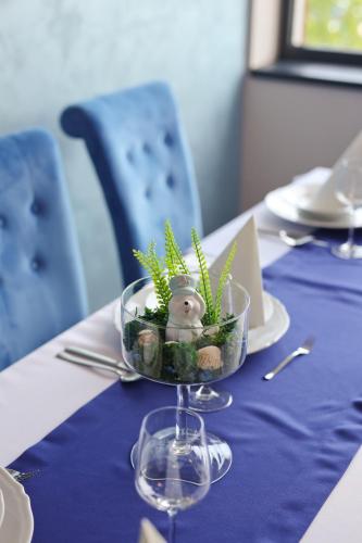 a table with a blue table cloth with a bowl of plants at Hotel Prístav in Trstená
