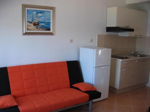 an orange couch in a kitchen with a refrigerator at Apartment in Sevid with Seaview, Balcony, Air condition, WIFI (4755-4) in Sevid