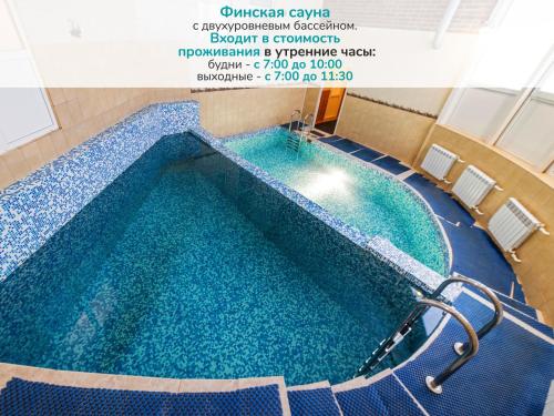uma grande piscina com água azul em Hotel House of the Hunter em Toksovo